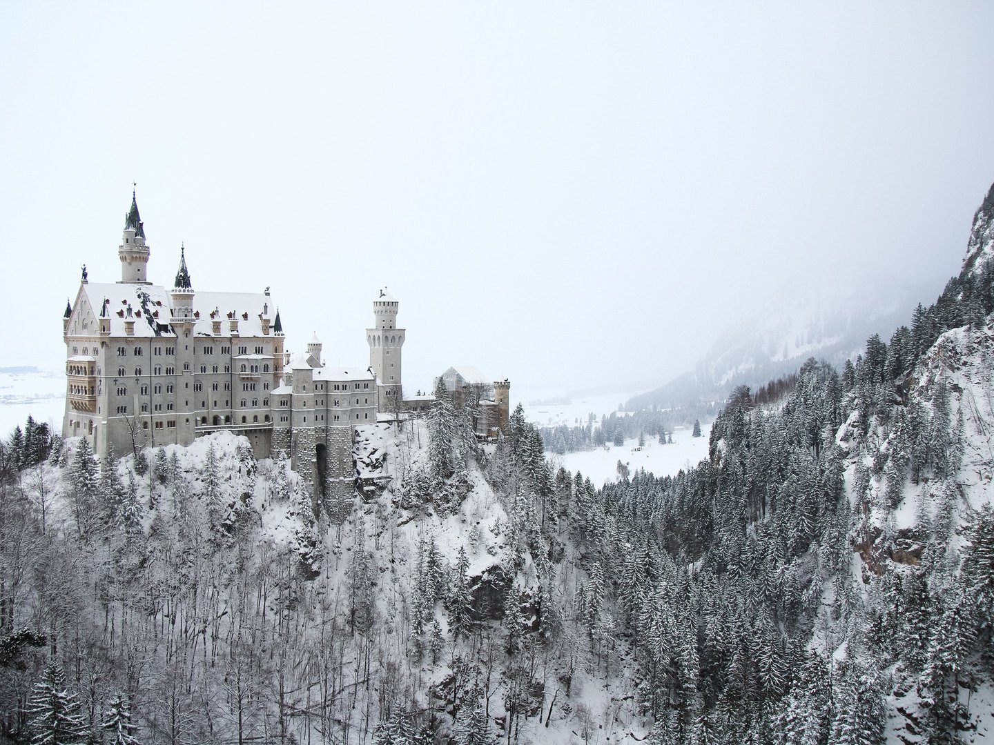 Winteraktivitäten rund um das Hotel Sommer Schloss Neuschwanstein im Winter mit schneebedeckten Bäumen und Bergen