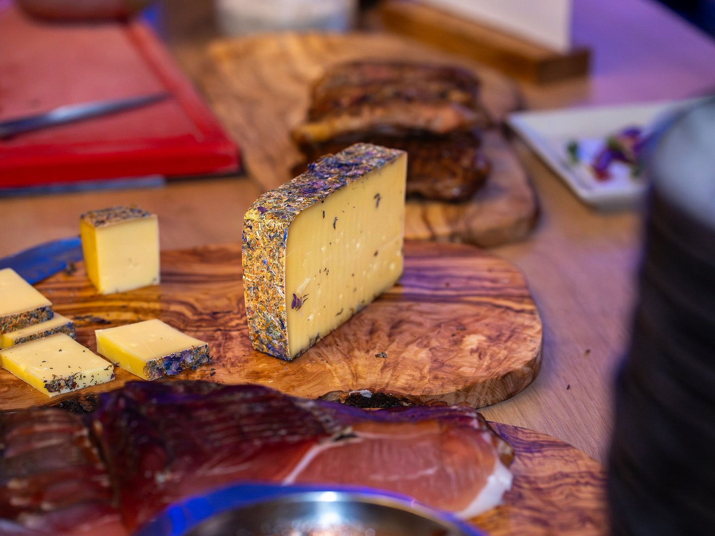 Urlaub mit dem Fahrrad | Hotel Sommer im Allgäu Käse mit Kräuterrinde und geschnittene Scheiben auf Holzbrett